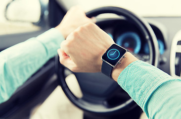 Image showing close up of male hands with wristwatch driving car