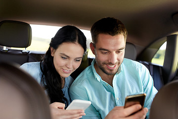 Image showing man and woman with smartphones driving in car