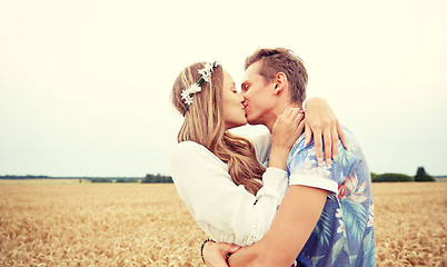 Image showing happy young hippie couple kissing in field