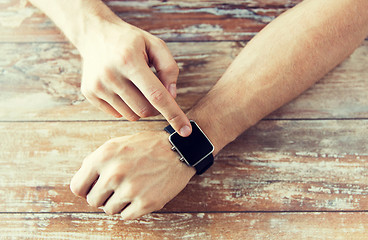 Image showing close up of male hands setting smart watch