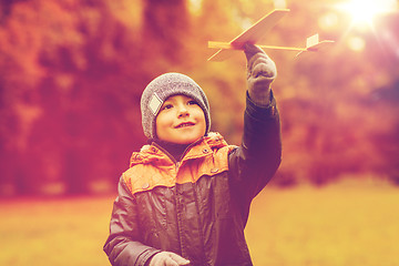 Image showing happy little boy playing with toy plane outdoors