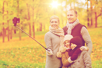 Image showing happy family with smartphone and monopod in park