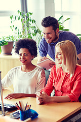 Image showing happy creative team with computer in office