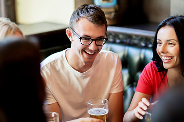 Image showing happy friends drinking beer at bar or pub