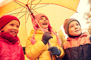 Image showing happy children with umbrella in autumn park