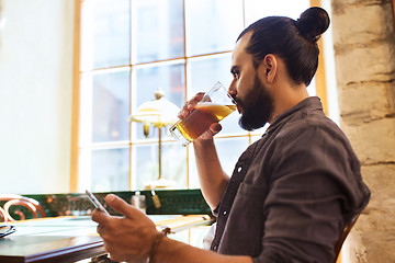 Image showing man with smartphone drinking beer at bar or pub