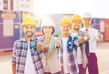 Image showing group of smiling builders in hardhats outdoors