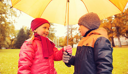 Image showing happy boy and girl with umbrella in autumn park