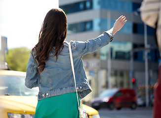 Image showing young woman or girl catching taxi on city street