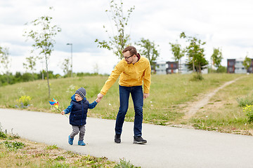 Image showing happy father and son with pinwheel toy outdoors