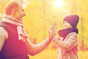 Image showing happy father and son making high five in park