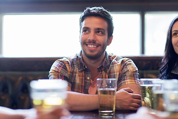 Image showing happy friends drinking beer at bar or pub