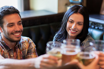 Image showing happy friends drinking beer at bar or pub