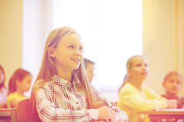 Image showing group of school kids with notebooks in classroom