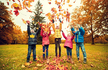 Image showing happy children playing with autumn leaves in park