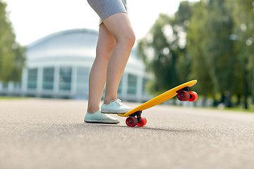 Image showing close up of female feet riding short skateboard