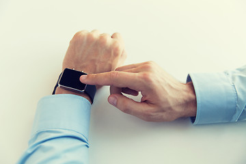 Image showing close up of male hands setting smart watch