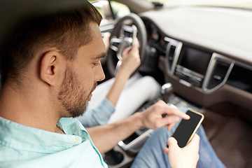 Image showing man and woman with smartphones driving in car