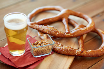 Image showing close up of beer, pretzels and peanuts on table