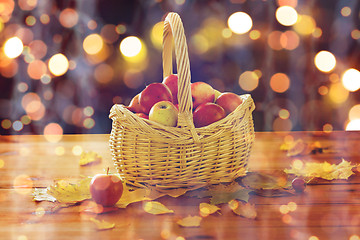 Image showing close up of basket with apples on wooden table