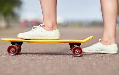 Image showing close up of female feet riding short skateboard