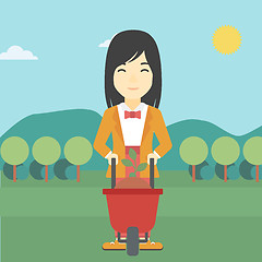 Image showing Woman with plant and wheelbarrow.