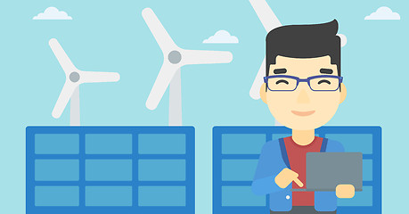 Image showing Man checking solar panels and wind turbines.