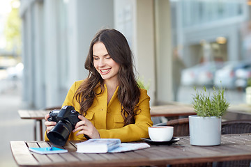 Image showing happy tourist woman with camera at city cafe