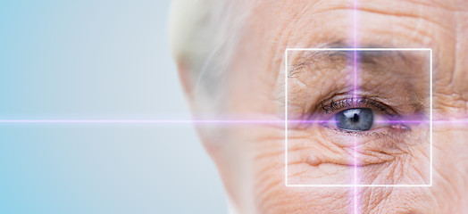 Image showing close up of senior woman eye with laser light