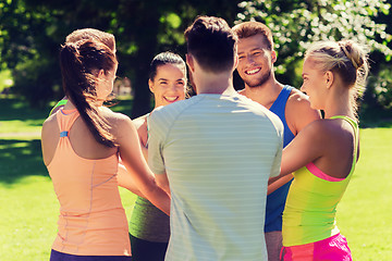 Image showing group of happy friends with hands on top outdoors