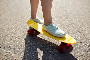 Image showing close up of female feet riding short skateboard