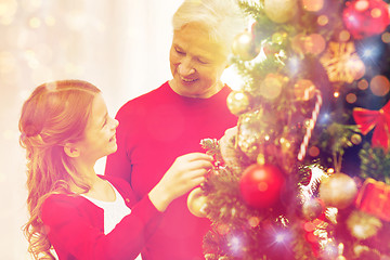 Image showing smiling family decorating christmas tree at home