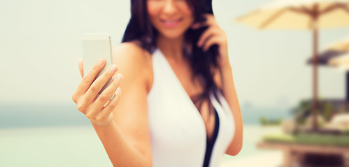 Image showing young woman taking selfie with smartphone on beach