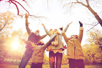 Image showing happy family playing with autumn leaves in park