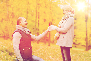 Image showing smiling couple with engagement ring in gift box