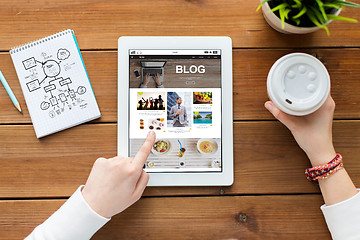 Image showing close up of woman with tablet pc on wooden table