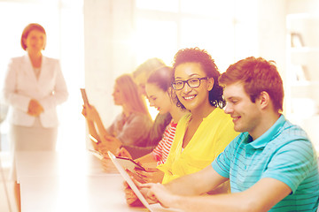 Image showing smiling female students with tablet pc at school