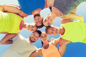 Image showing group of happy sporty friends in circle outdoors