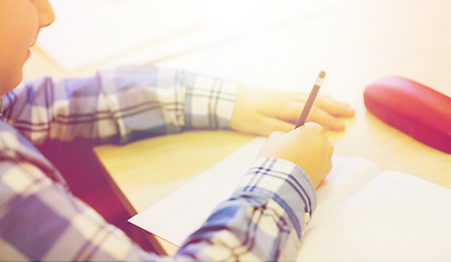 Image showing close up of schoolboy writing test at school