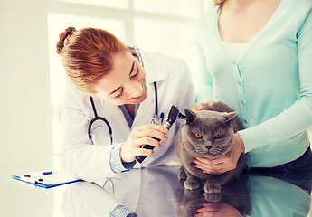 Image showing happy woman with cat and doctor at vet clinic