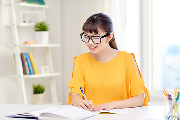 Image showing happy asian young woman student learning at home