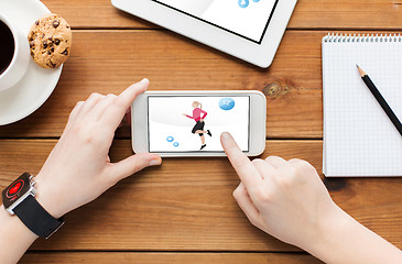 Image showing close up of woman with fitness app on smartphone