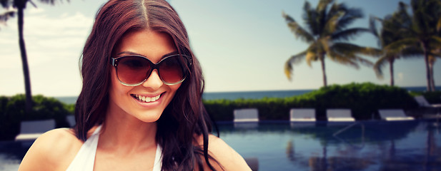 Image showing smiling young woman with sunglasses on beach