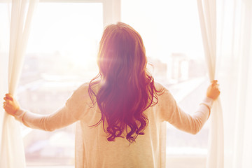 Image showing close up of woman opening window curtains