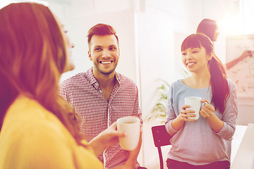 Image showing happy creative team drinking coffee at office