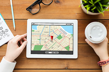 Image showing close up of woman with tablet pc on wooden table