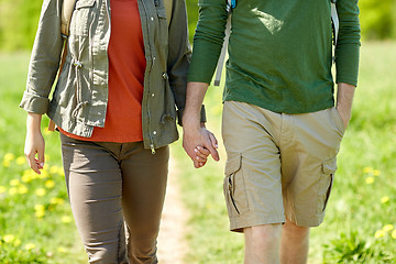 Image showing close up of couple with backpacks holding hands