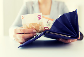 Image showing close up of woman hands with wallet and euro money