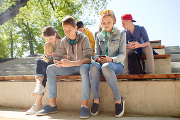 Image showing group of teenage friends with smartphones outdoors