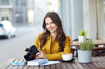 Image showing happy tourist woman with camera at city cafe